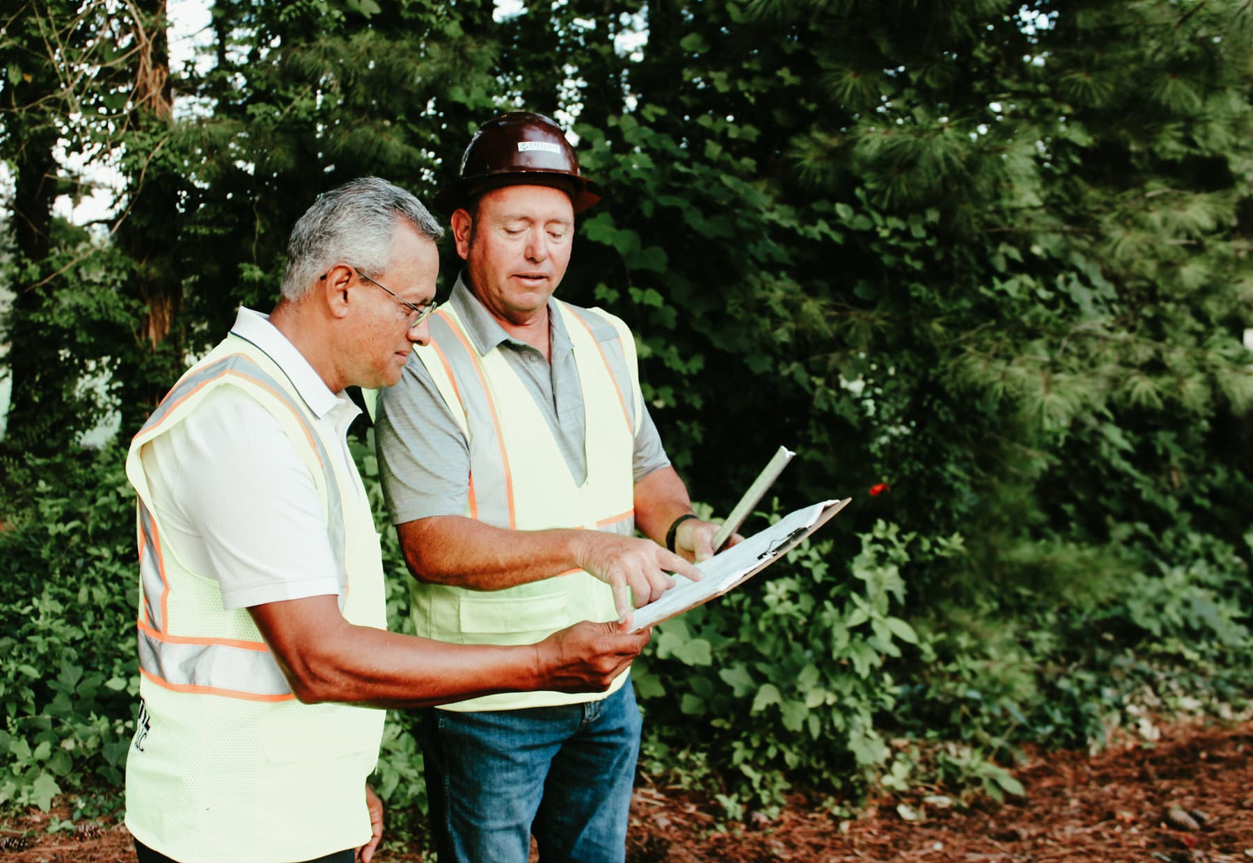 Excellere team members reviewing construction plans together in the field